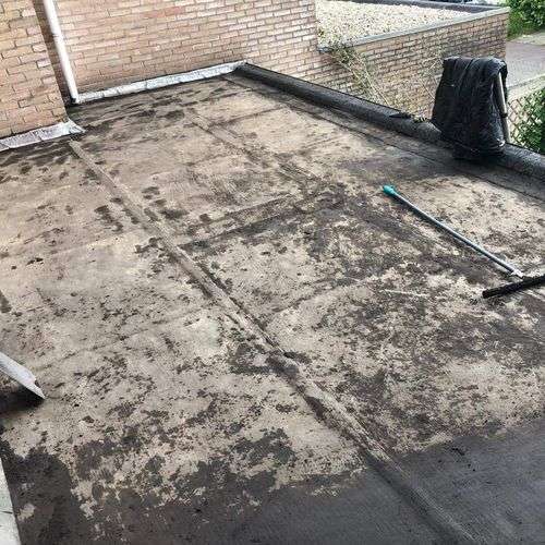 Schoonmaken van een plat dak in Groesbeek